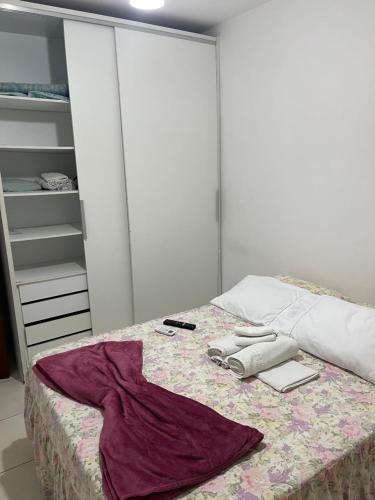 a bedroom with a bed with a robe on it at Pé na areia in Ilhéus