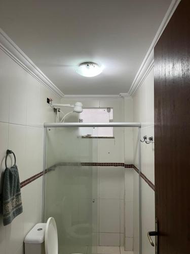 a bathroom with a glass shower with a toilet at Pé na areia in Ilhéus