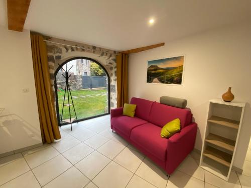 a living room with a red couch and a window at L'Oustal Des Dômes in Orcines