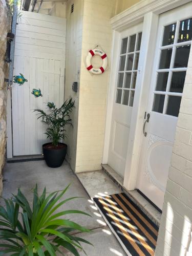 a front door of a house with a wreath and a plant at 3 Bedroom Beach House in Coogee in Sydney