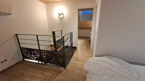 a bedroom with a bed and a hallway with a stair case at Nid Douillet des Forges in Plombières-les-Bains