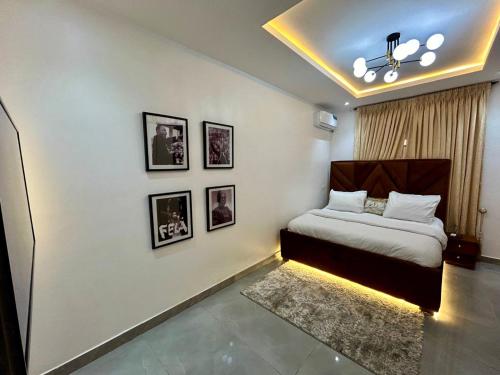 a bedroom with a bed and pictures on the wall at Providence LUXE 3 Bed Apartment in Lekki