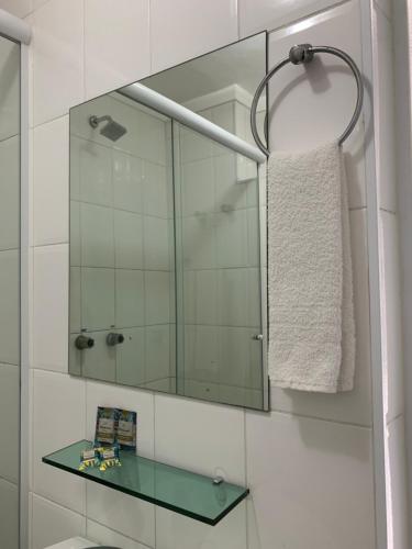 a bathroom with a mirror and a glass shelf at Lory Studio Hotel in São Paulo