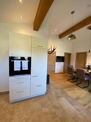 a kitchen with white cabinets and a dining room at Ferienwohnung Plechau in Russbach am Pass Gschütt