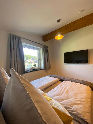 a bedroom with a bed and a flat screen tv at Ferienwohnung Plechau in Russbach am Pass Gschütt