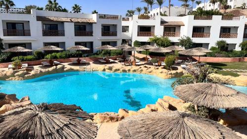 a resort with a large swimming pool with umbrellas at Domina Coral Bay Elisir in Sharm El Sheikh