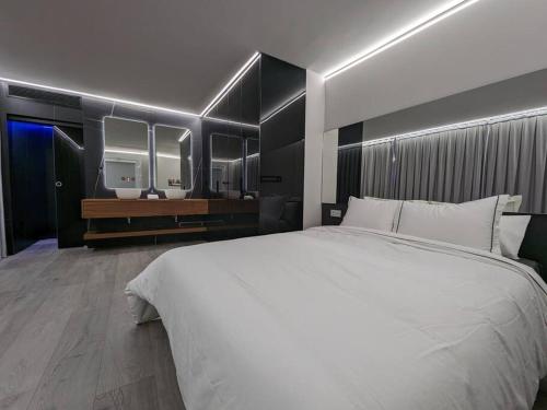 een slaapkamer met een groot wit bed en 2 wastafels bij Murcia Luxury Plaza de las Flores Apartment in Murcia