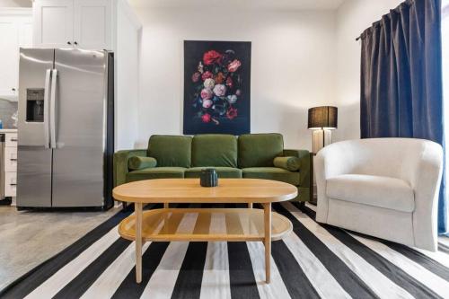 a living room with a couch and a table and a refrigerator at Teche House KING Bed Luxury Getaway Fast WiFi in Lafayette