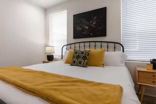 a bedroom with a bed with a yellow blanket on it at Teche House KING Bed Luxury Getaway Fast WiFi in Lafayette