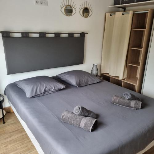 a bed with two pillows and two towels on it at Gîte 1 Newlook in Trélissac