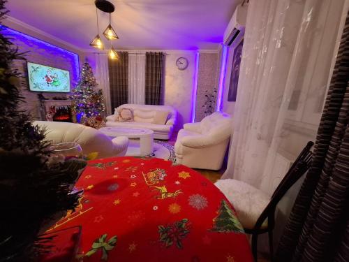 a living room with a christmas tree and a room with a christmas at Royal Place Apartment - East Sarajevo in Lukavica
