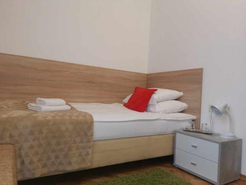 a bedroom with a bed with a red pillow on it at Eisenerzer Apartments - Radmeisterhaus in Eisenerz