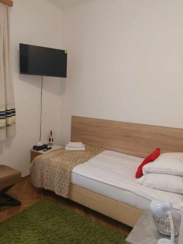 a bedroom with a bed and a flat screen tv at Eisenerzer Apartments - Radmeisterhaus in Eisenerz