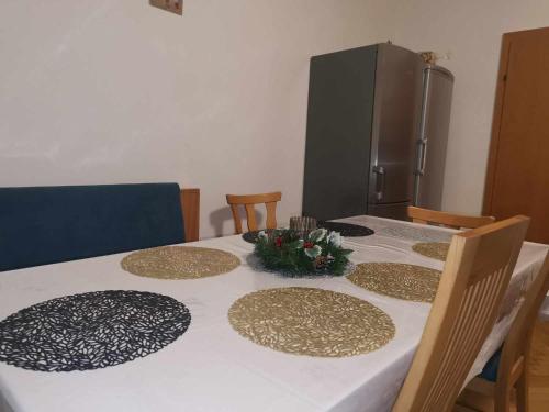 a kitchen table with a white table cloth and a refrigerator at Eisenerzer Apartments - Radmeisterhaus in Eisenerz