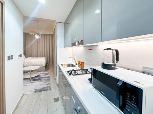 une cuisine avec un évier et un micro-ondes dans l'établissement Luxury Studio near burj khalifa in Azizi Riviera, à Dubaï