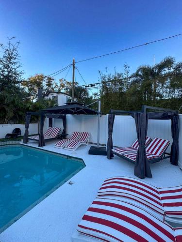 a swimming pool with two lounge chairs and a gazebo at Prestige Collection, Hotel Boutique in St Petersburg
