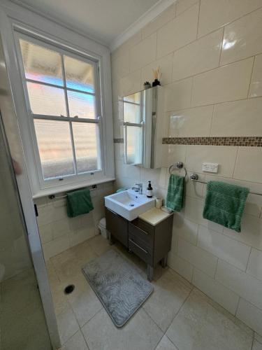 a bathroom with a sink and a window at 3 Bedroom Beach House in Coogee in Sydney