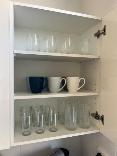 a shelf filled with glass mason jars and cups at 3 Bedroom Beach House in Coogee in Sydney