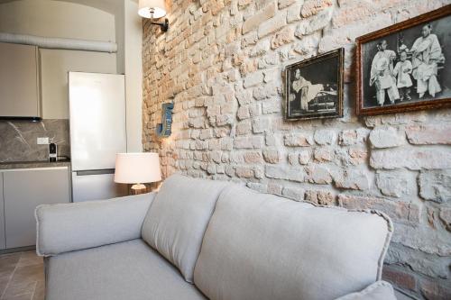 a brick wall with a couch in a living room at Le Antiche Mura in Guastalla