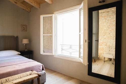 a bedroom with a bed and a large window at Le Antiche Mura in Guastalla