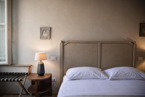a bedroom with a bed and a table with a lamp at Le Antiche Mura in Guastalla
