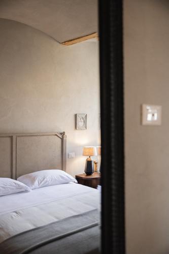 a bedroom with two beds and a table with a lamp at Le Antiche Mura in Guastalla