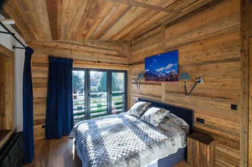 Cette cabane en rondins comprend un lit et une télévision. dans l'établissement Chalet 8 Etoiles, à Chamonix-Mont-Blanc