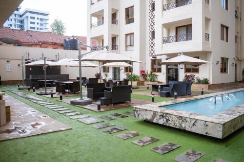 a pool with chairs and umbrellas next to a building at Nairobi City view1 BDRM condo with pool and gym in Nairobi