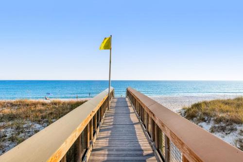 a boardwalk to the beach with a flag on it at Gulf Island 733 in Navarre