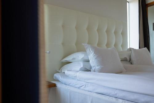 a bedroom with a white bed with white pillows at Avalon Hotel in Gothenburg