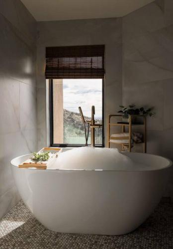 a large white bath tub in a room with a window at BEST VIEWS in Albuquerque with hot tub and pool in Albuquerque