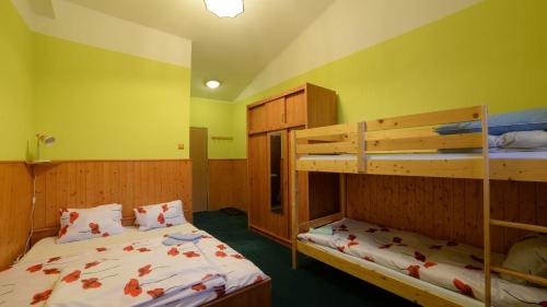 two bunk beds in a room with yellow walls at Penzion Krmelec in Tanvald