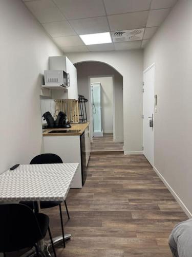 une pièce vide avec une cuisine, une table et des chaises dans l'établissement Logement centre-ville Muret, à Muret