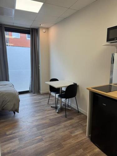 une chambre avec un lit, une table et des chaises dans l'établissement Logement centre-ville Muret, à Muret