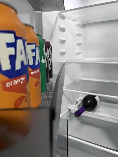an open refrigerator with a carton of orange soda at Bloom Court -Sleeps 6-Free Parking with Workspace & High-Speed WiFi in Birmingham