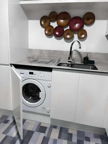 a kitchen with a sink and a washing machine at Bloom Court -Sleeps 6-Free Parking with Workspace & High-Speed WiFi in Birmingham