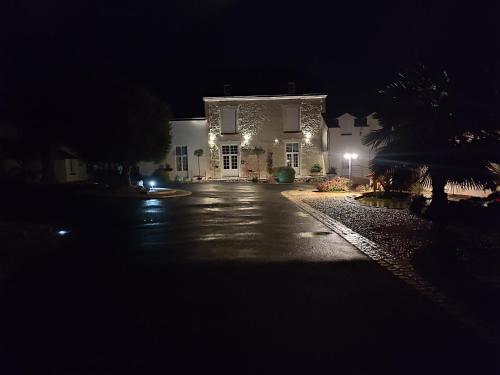a large white house at night with lights on it at LA MAISON D'ALIDA in Nueil-sous-Faye