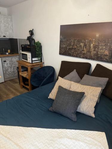 - un lit avec des draps et des oreillers bleus dans l'établissement Chez edGARE à Chambéry, à Chambéry