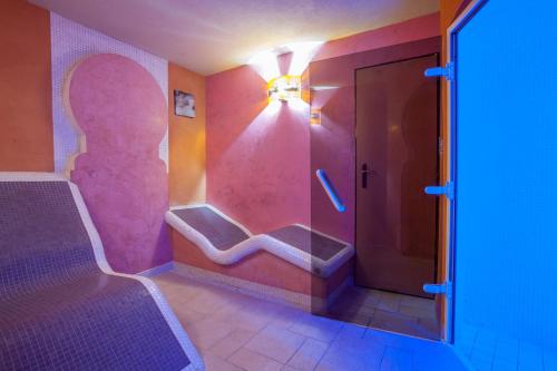 a bathroom with a shower with a pink wall at Hotel Magnus Trenčín in Trenčín