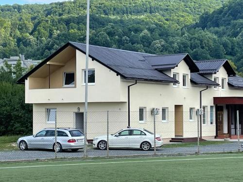 two cars parked in front of a house at Apartmani Sun & Moon in Žepče