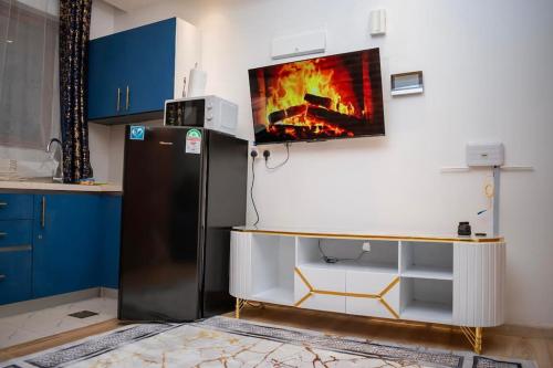 a kitchen with a refrigerator and a tv on the wall at Nairobi City view1 BDRM condo with pool and gym in Nairobi
