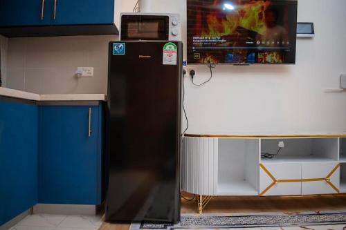 a black refrigerator in the corner of a kitchen at Nairobi City view1 BDRM condo with pool and gym in Nairobi