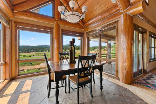 a dining room with a table and chairs and windows at Reunion Lodge in Sturgis