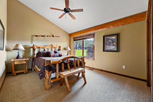a bedroom with a wooden bed and a ceiling fan at Reunion Lodge in Sturgis