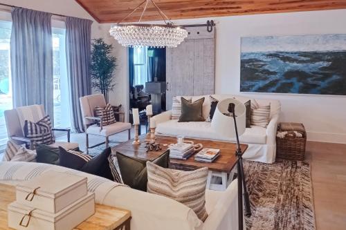 a living room with white furniture and a chandelier at The Rookery in Blackbanks