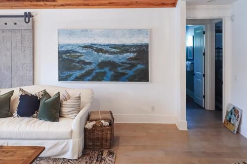 a living room with a white couch and a painting on the wall at The Rookery in Blackbanks