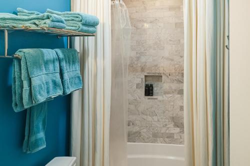 a bathroom with a shower with blue towels at The Rookery in Blackbanks