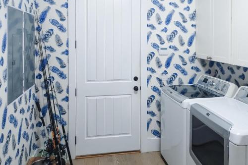 a white door in a kitchen with blue and white wallpaper at The Rookery in Blackbanks
