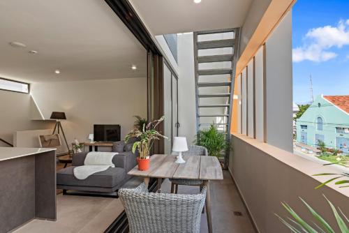 Una sala de estar con una mesa y sillas y un sofá. en Island Time Retreat, en Willemstad