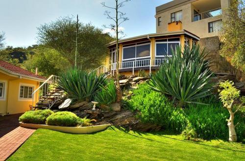 a house with a yard with plants in front of it at Villa Moringa Guesthouse in Windhoek